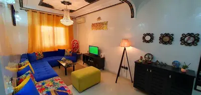 a living room with a blue couch and a television at Hébergement sabrina in Fès
