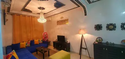 a living room with a blue couch and a tv at Hébergement sabrina in Fès