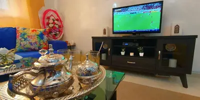 a living room with a tv and a coffee table at Hébergement sabrina in Fès