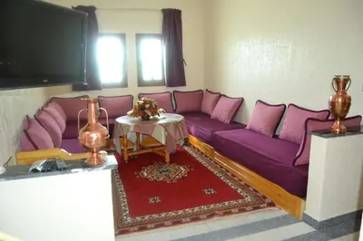 a living room with purple couches and a table at Résidence Ayour in Ouarzazate