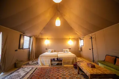 a bedroom in a tent with a bed and a table at beduincamp in Hassilabied