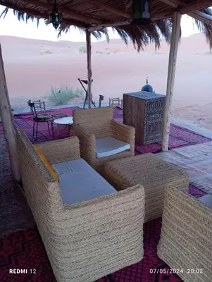 a group of wicker chairs and tables on the beach at beduincamp in Hassilabied