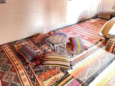 a room with a floor with colorful rugs on it at beduincamp in Hassilabied