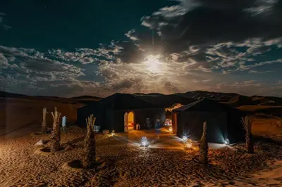 a black tent in the middle of the desert at night at beduincamp in Hassilabied