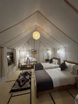 a hotel room with two beds and a couch at Luxury Nomad Style in Merzouga