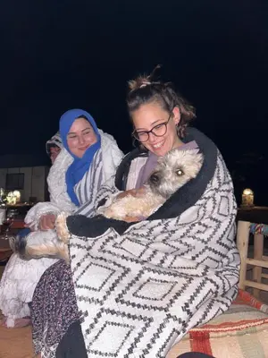 two women are holding a dog in a blanket at Luxury Nomad Style in Merzouga