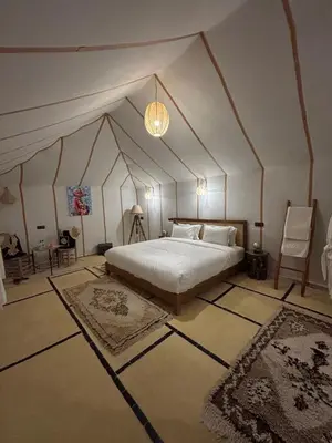 a bedroom with a large bed in a tent at Luxury Nomad Style in Merzouga