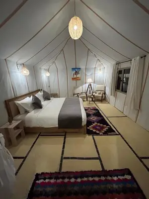 a bedroom with a bed in a tent at Luxury Nomad Style in Merzouga