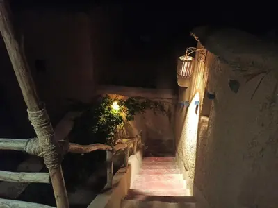 an alleyway with stairs and a light at night at Trésors des Ancêtres in Ibrahene