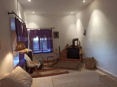 a living room with a bed and a fireplace at Trésors des Ancêtres in Ibrahene