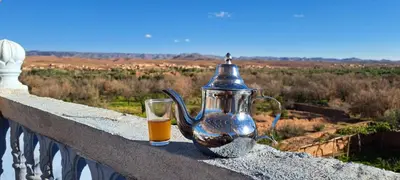 a tea pot and a glass of orange juice on a ledge at Dar Mayssa Rose in Zawyat