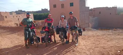 a group of people standing with bikes in front of a building at Dar Mayssa Rose in Zawyat