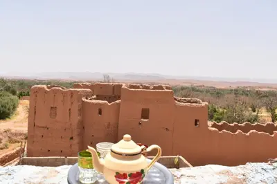 a tea set on a table in front of a building at Dar Mayssa Rose in Zawyat