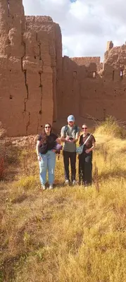 a group of people standing in a field in front of ruins at Dar Mayssa Rose in Zawyat