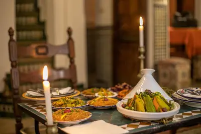 a table with plates of food on it with candles at Dar Authentic Fes - familly hosting in Fès