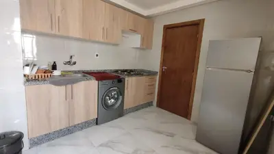 a kitchen with a stove and a washer and a refrigerator at coin famille in Fès