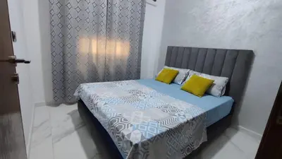 a bedroom with a bed with two yellow pillows at coin famille in Fès