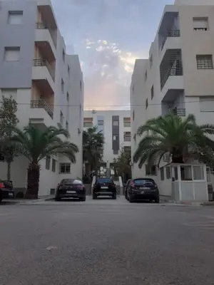 three cars parked in a parking lot in front of a building at coin famille in Fès