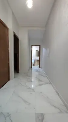 an empty room with white walls and marble floors at coin famille in Fès