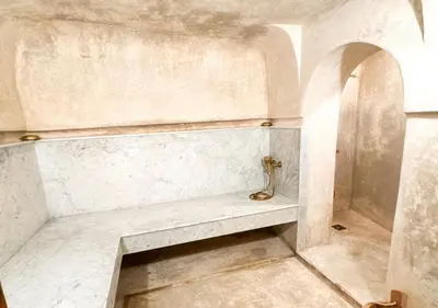 a bathroom with a shower with a bench in it at Riad Dar Timrad in Fès