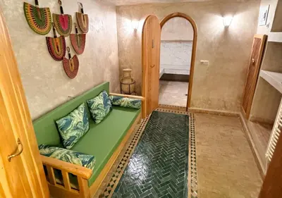 a living room with a green couch in a room at Riad Dar Timrad in Fès