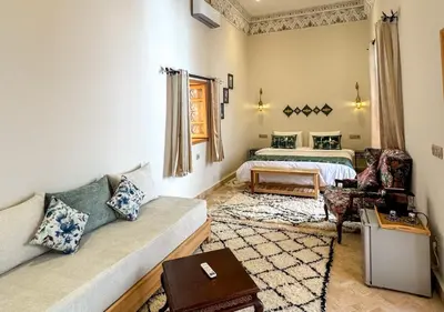 a living room with a bed and a couch at Riad Dar Timrad in Fès