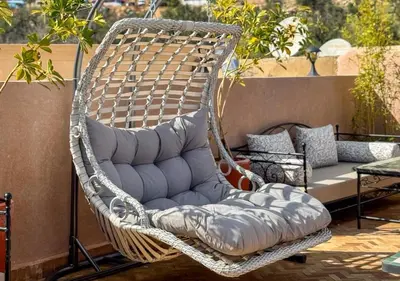 a wicker swing chair sitting on a patio at Riad Dar Timrad in Fès