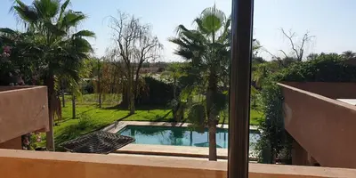 a view of a swimming pool through a window at Maison d'Hôtes à Marrakech in Marrakech