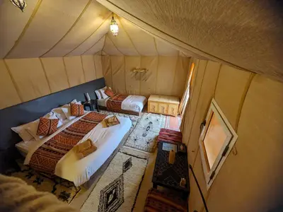an overhead view of two beds in a tent at abja luxury camp in Merzouga