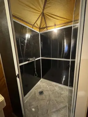a shower with a glass door in a bathroom at abja luxury camp in Merzouga