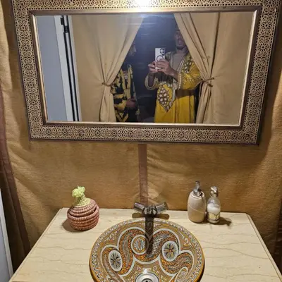 a person taking a picture in a mirror above a table at abja luxury camp in Merzouga