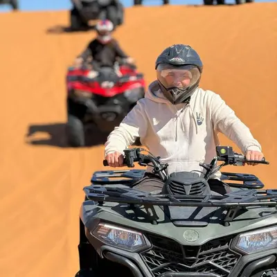 a man is riding a motorcycle on a field at abja luxury camp in Merzouga