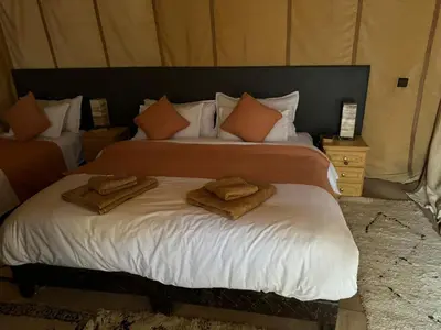 a bedroom with two beds with towels on them at abja luxury camp in Merzouga