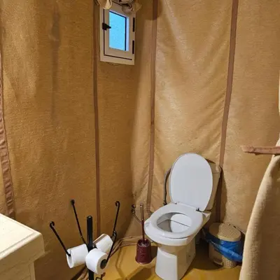 a bathroom with a toilet and two rolls of toilet paper at abja luxury camp in Merzouga