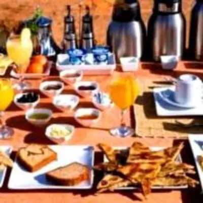 a table with plates of food and glasses of orange juice at abja luxury camp in Merzouga