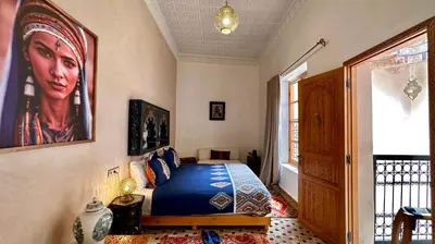 a bedroom with a bed and a portrait of a woman at Alibaba Riad in Fès