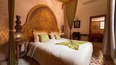 a bedroom with a large bed with an ornate headboard at Alibaba Riad in Fès