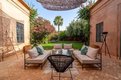 a patio with a couch and a table and chairs at Villa Izza in Marrakech