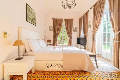 a bedroom with a large white bed and windows at Villa Izza in Marrakech