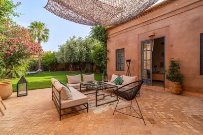 a patio with a table and chairs and a building at Villa Izza in Marrakech