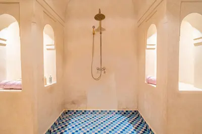 a bathroom with a shower and a blue tile floor at Villa Izza in Marrakech