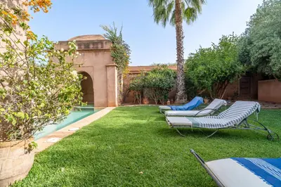 a yard with two lounge chairs and a swimming pool at Villa Izza in Marrakech