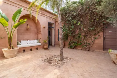 a courtyard with a couch and a palm tree at Villa Izza in Marrakech