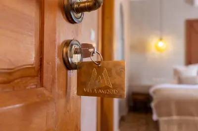 a wooden door with a sign on it at Riad Villa Amood in Merzouga