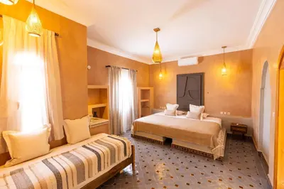 a hotel room with two beds and a window at Riad Villa Amood in Merzouga