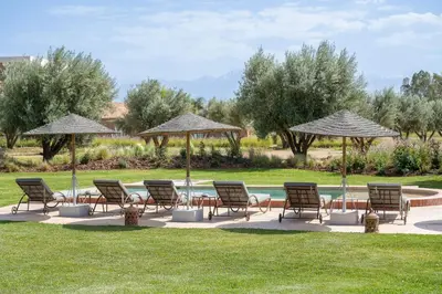 a group of chairs and umbrellas next to a pool at Dar Syada Boutique Hotel & SPA Marrakech in Marrakech