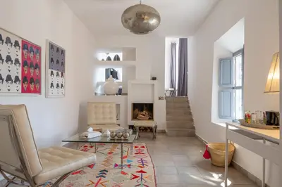 a living room with a chair and a table and a fireplace at Dar Syada Boutique Hotel & SPA Marrakech in Marrakech