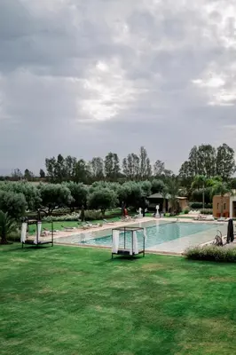 a swimming pool in a park with green grass at Dar Syada Boutique Hotel & SPA Marrakech in Marrakech