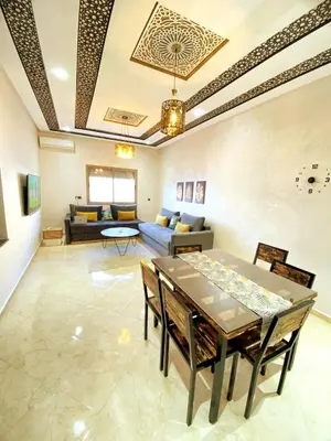 a living room with a table and a couch at Appartement calme top in Fès