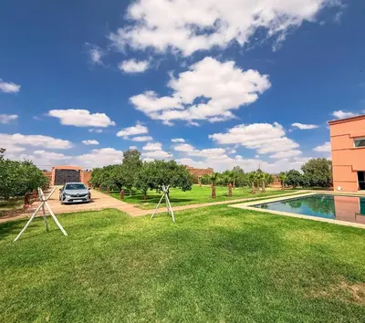 a car parked in a yard next to a swimming pool at L'Oasis Villa in Marrakech